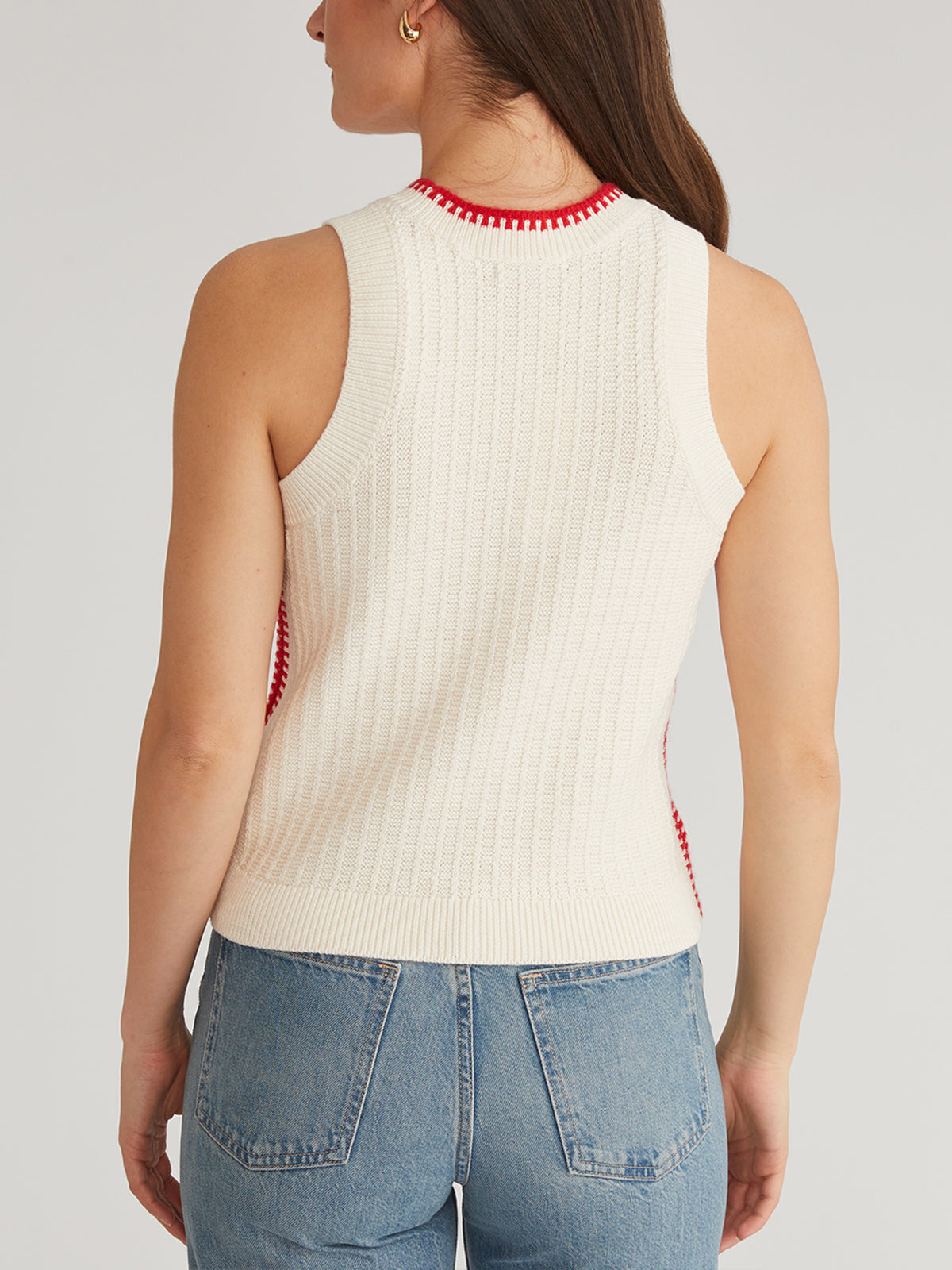 A person wearing a 525 America Demi Mini Cable Tipped Tank with red accents is seen from the back, paired with light blue jeans. The classic crewneck adds elegance against a plain, neutral background.